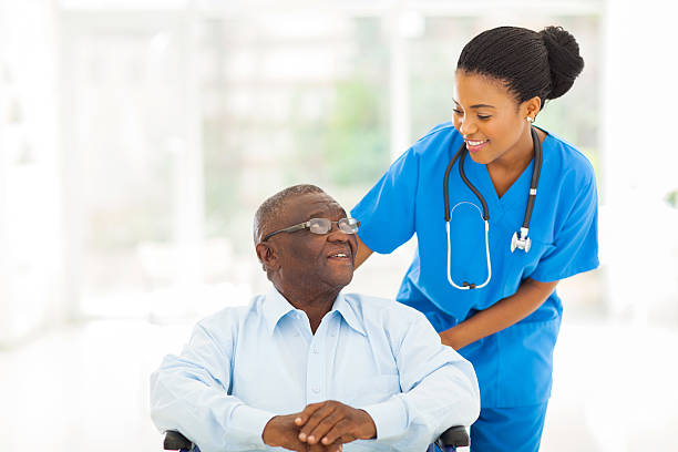infermiera africana, prendersi cura del paziente anziano in sedia a rotelle - patient retirement senior adult hospital foto e immagini stock