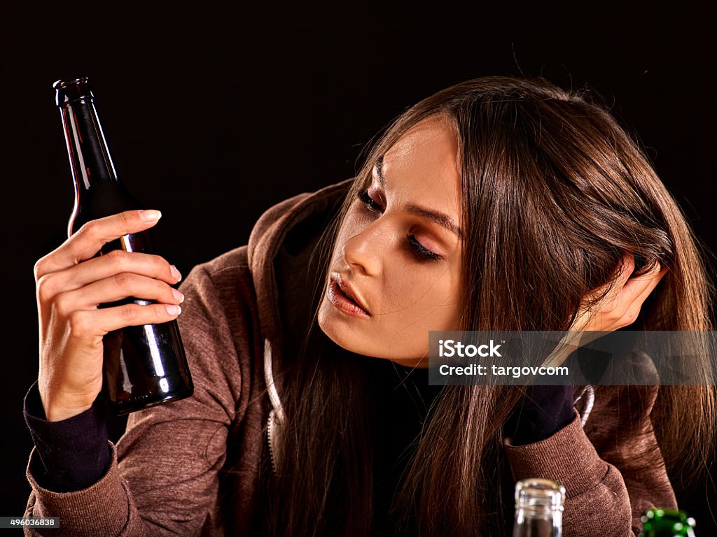 Drunk girl holding bottle of vodka Drunk girl looking at bottle of alcohol. Soccial issue alcoholism. 20-29 Years Stock Photo