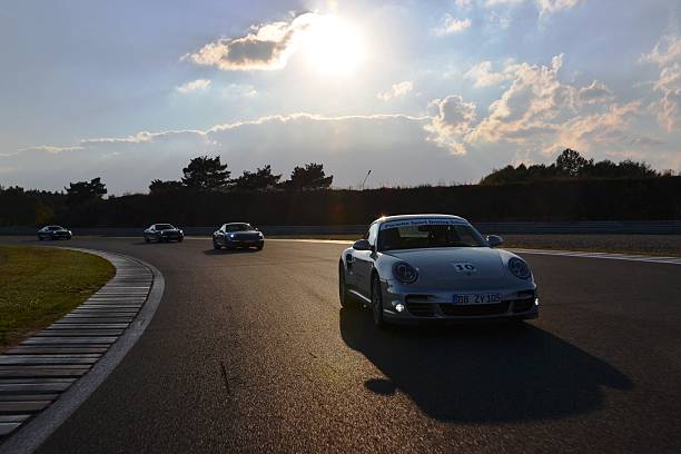 Poznan, Poland - October 3rd, 2012: Porsche 911 (991) with Sport Driving School driving by journalists at the Poznan Racetrack in Poland. The cheapest model of Porsche 911 is powered by 3.4-litre petrol engine pushing out 350 HP, but the most expensive (Turbo S) is powered by 3.8-litre petrol engine pushing out 560 HP. The Turbo S sprints from 0 to 100 km/h (62 mph) in 3.1 seconds and top speed is 318 km/h. The Poznan circuit is one of the best circuits in Eastern Europe for a driver training.