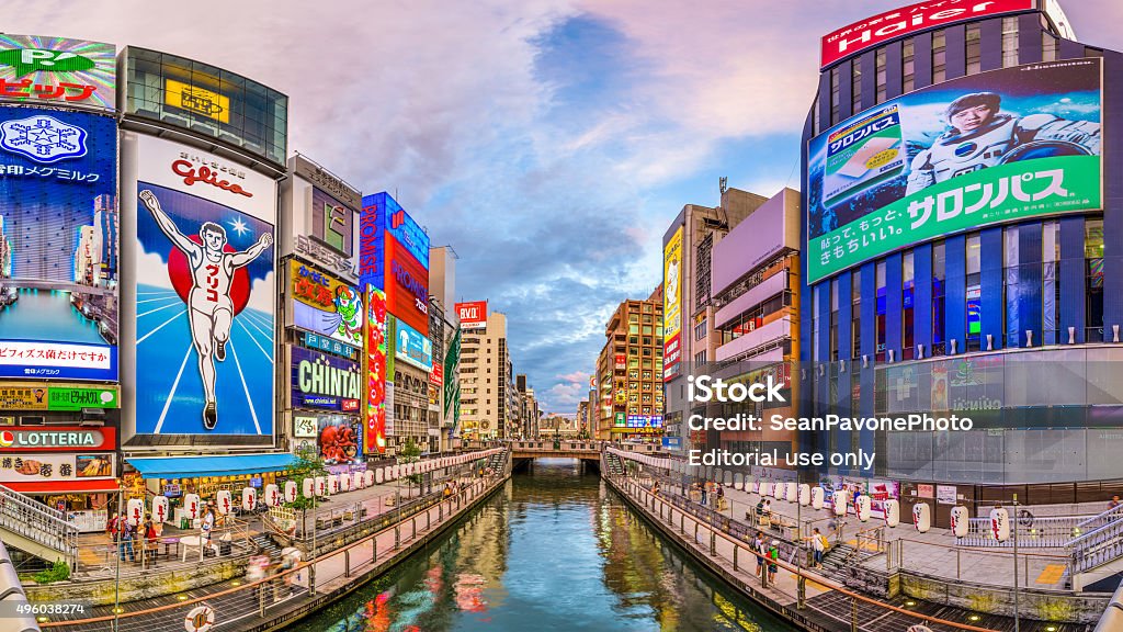 Dotonbori Osaka Skyline Osaka, Japan - August 16, 2015: Tourists walk along the Dotonbori Canal in the Namba District. The canal dates from the early 1600's and is now a popular commercial district and tourist attraction. Dōtonbori Stock Photo