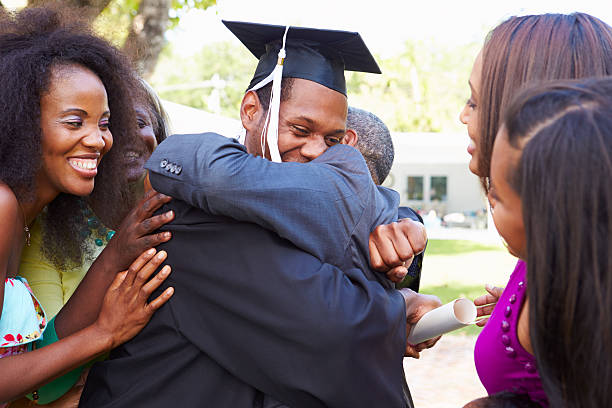 African American Student Celebrates Graduation African American Student Celebrates Graduation Smiling college student and parent stock pictures, royalty-free photos & images