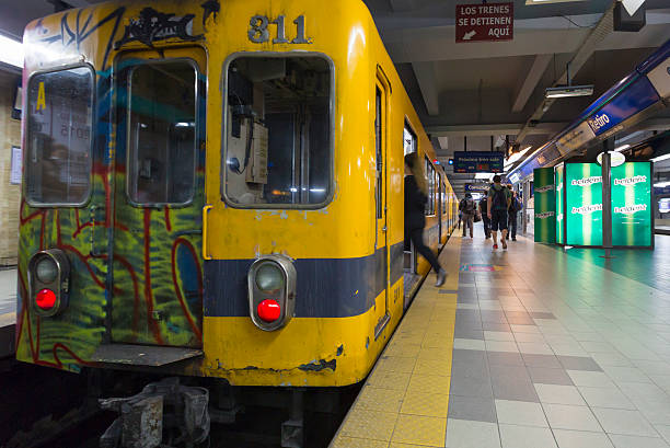 A blurry image captures the speed and movement of a subway train traveling through an underground station, highlighting urban life and fast-paced transportation.
