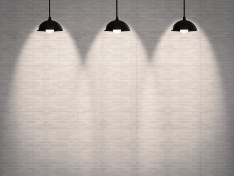 blank brick wall with three lamps hanging