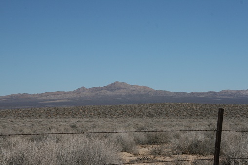Distant mountains in the Mojave desert. Barbed-wire fence in the foreground.