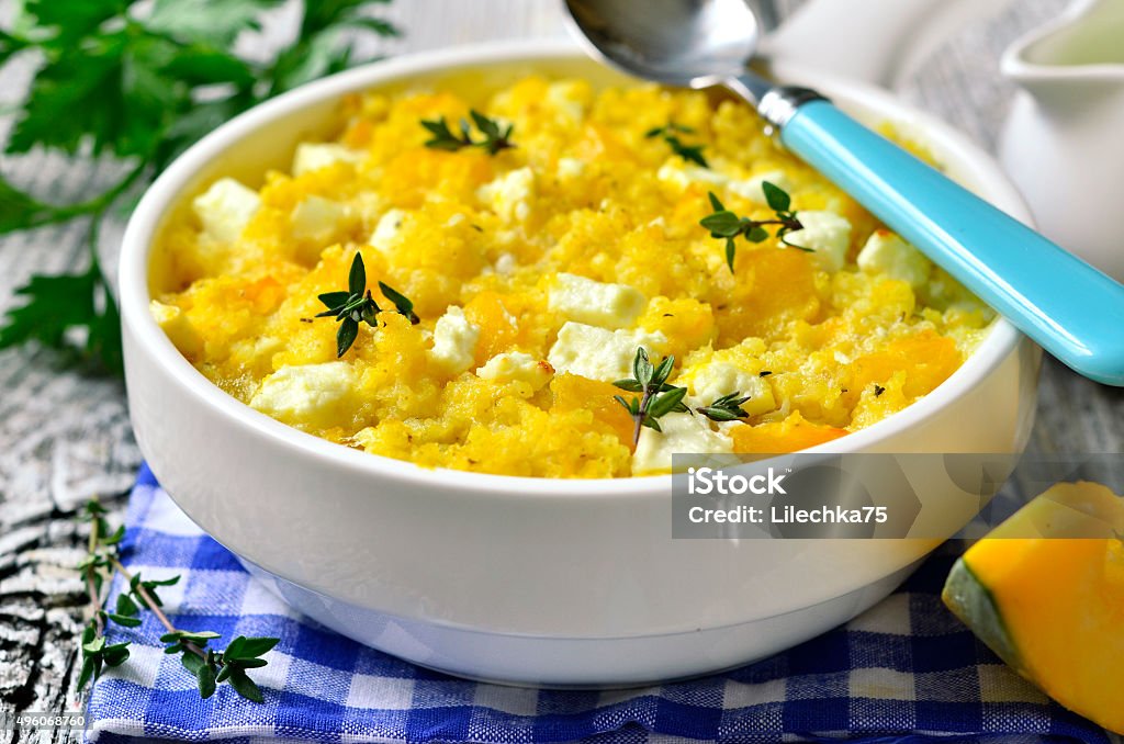 Spicy millet casserole with pumpkin and feta. Spicy millet casserole with pumpkin and feta on wooden table. 2015 Stock Photo