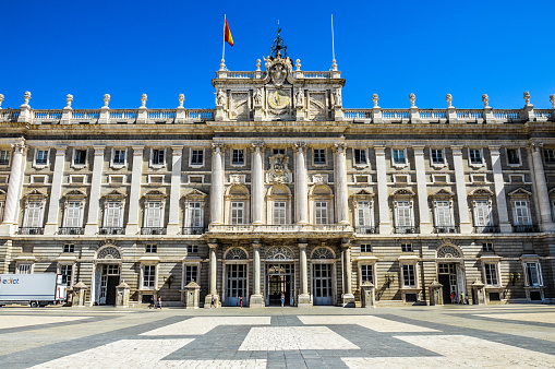 Madrid, Spain - August 6, 2015: The Royal Palace Palacio Real in Madrid, Spain. Photo taken during the day from the square in front, and contains tourists and locals walking about.