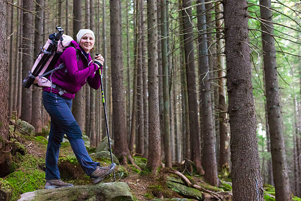 istock Smiling Female Hiker Staying in Deep Old Forest 496070568