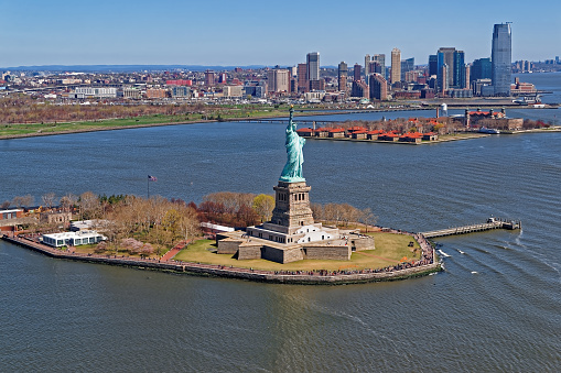 Aerial view of the Statue of Liberty in New York City, USA with Jersey City (NJ)  and Governors island in the background. The statue is an icon of freedom and of the United States