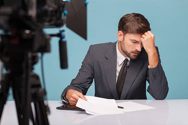 istock Handsome male newscaster is suffering from headache 496073080