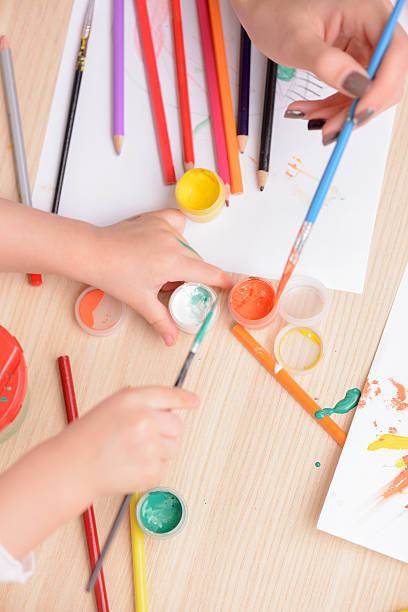 istock Cheerful woman and her child are drawing 496073696