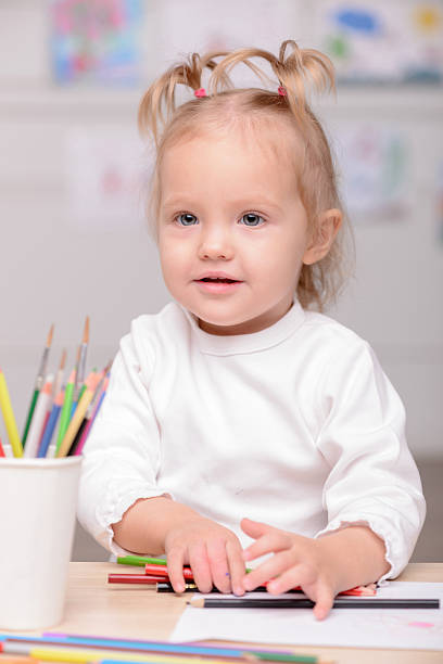 istock Cheerful small female child is drawing with joy 496073762