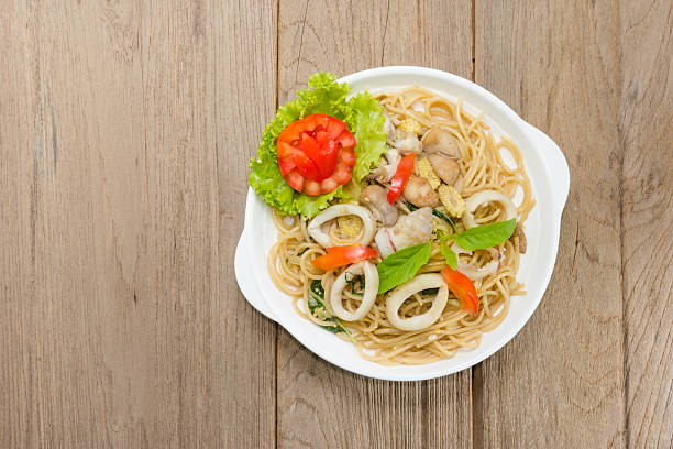 istock stir fried spaghetti with squid on wood background 496073928