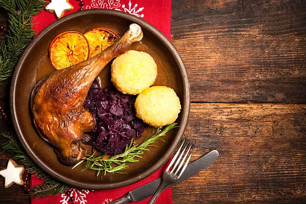 Crusty goose leg with braised red cabbage and dumplings. Cooking at Christmas time