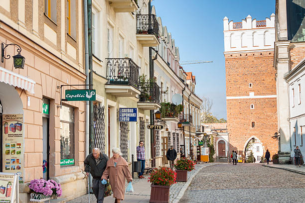 Sandomierz, Poland - October 16, 2015: Tourists walk past a cafeteria and souvenir store in Sandomierz. Sandomierz is among oldest towns in Poland, dating back to at least 1227.