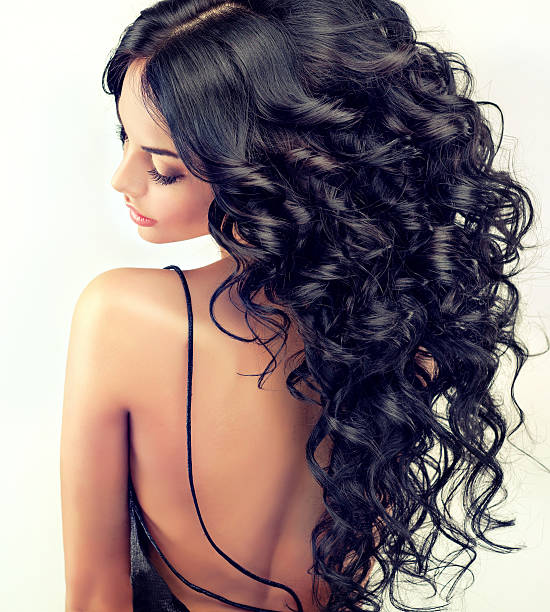 Beautiful girl model with long black curled hair. stock photo