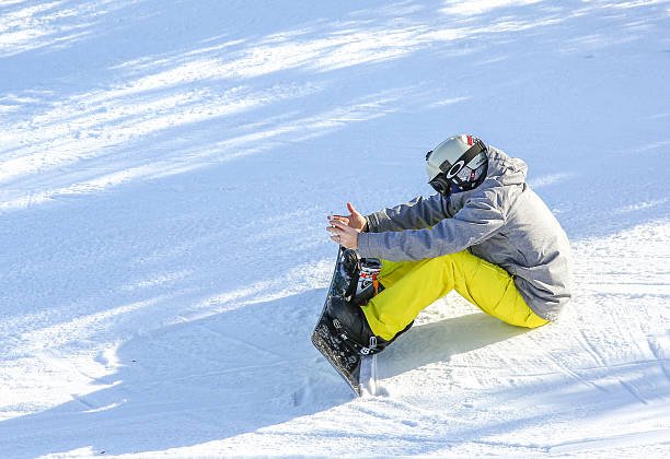 retrato de snowborder lectura de su smartphone - snowboarding snowboard teenager red fotografías e imágenes de stock