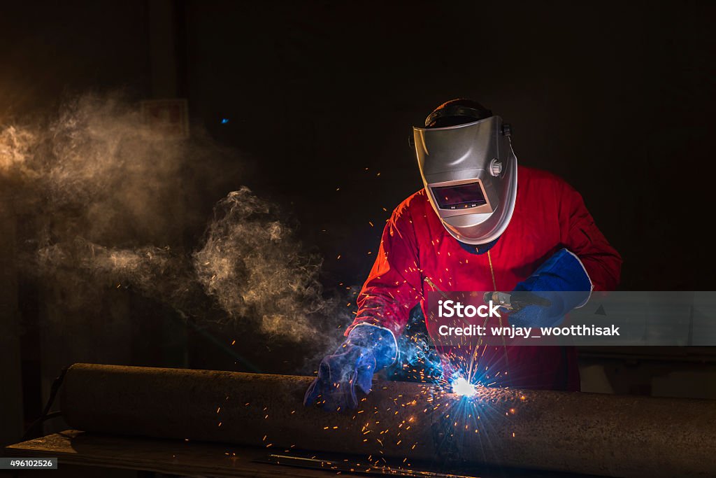 Welder metal steel Workshop welder in Red uniform Welder Stock Photo