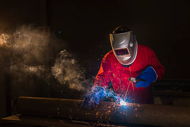 Welder metal steel Workshop welder in Red uniform power line photos stock pictures, royalty-free photos & images