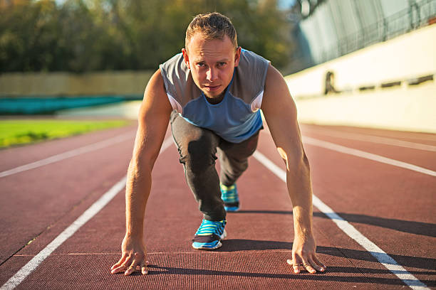 istock Athletic man standing in posture ready to run on treadmill 496105580