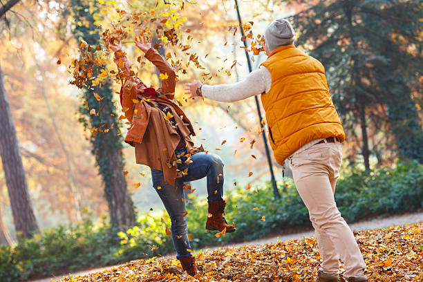istock Smiling couple throwing leaves in autumn park 496107930
