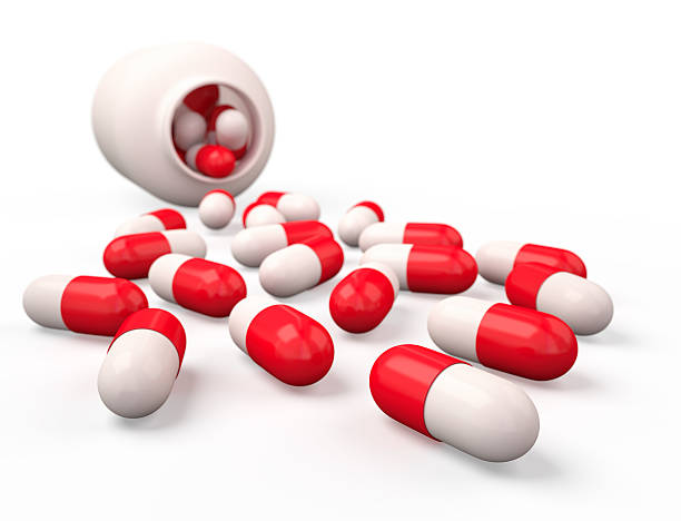 薬溢れの薬びん白で分離。 - vitamin pill red pill capsule ストックフォトと画像