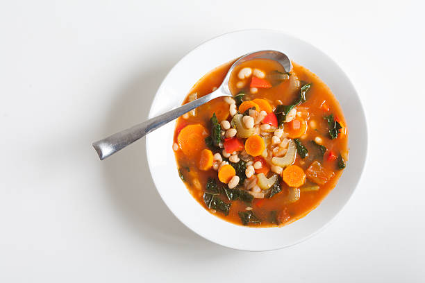 Vegetarian Vegetable Soup Vegan vegetable soup with kale, white beans, tomatoes, celery, carrots, red peppers. vegetable soup stock pictures, royalty-free photos & images