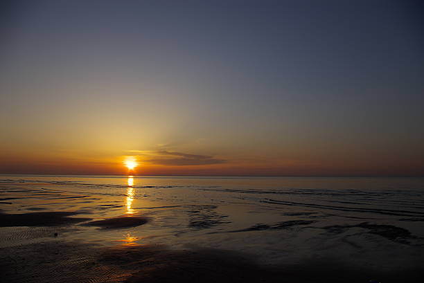 Beautiful orange blue sunset at Baltic sea with sun left