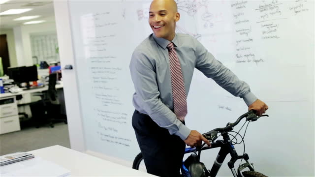 Businessman pushing bicycle through office