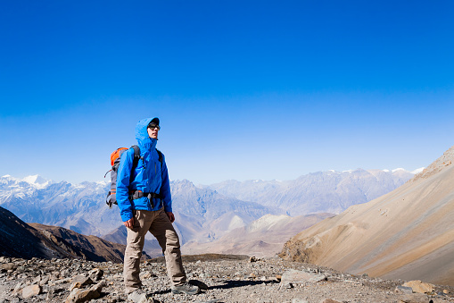 Hiker at the top of the high pass on Annapurna circuit trek in Nepal Himalaya