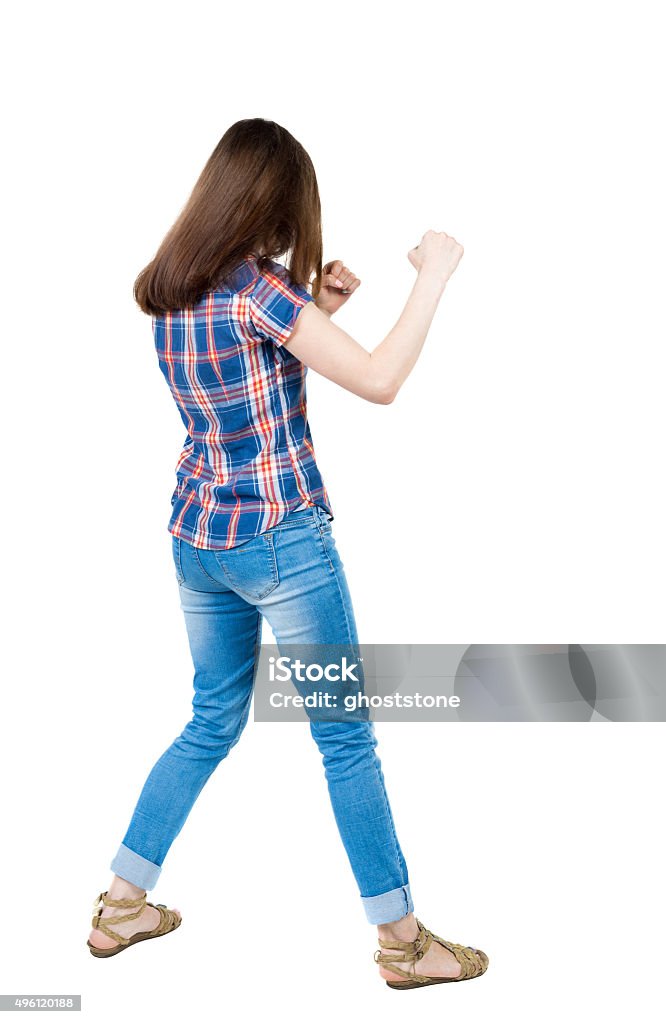 skinny woman funny fights waving his arms and legs. skinny woman funny fights waving his arms and legs. Isolated over white background. A young girl in a checkered blue with red stripes stands in boxing pose. 2015 Stock Photo