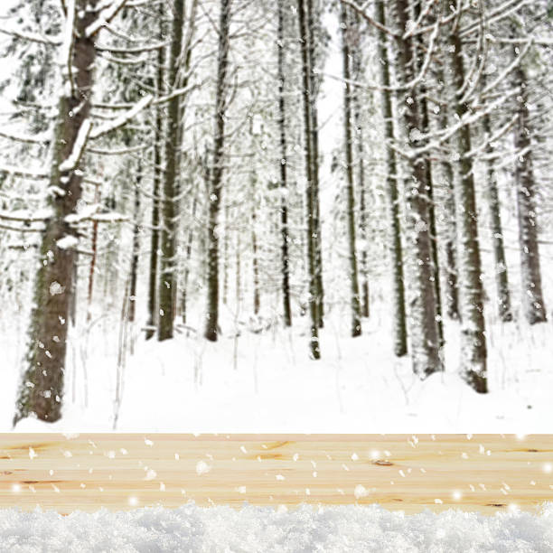 istock Blurred winter background with snow covered forest and shabby table 496123882
