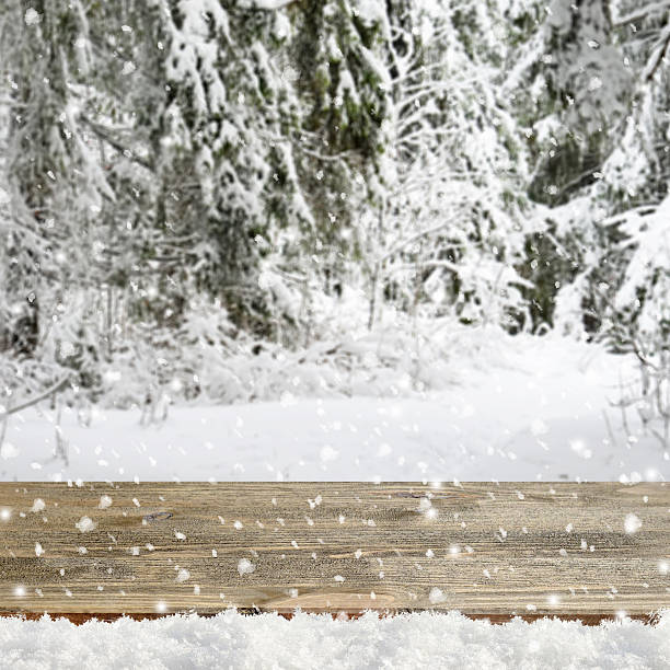istock Blurred winter background with snow covered forest and shabby table 496124012