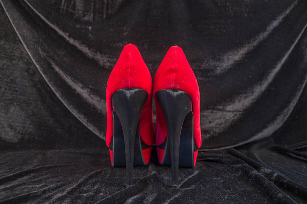 istock Women's red shoes isolated on black background 496124028
