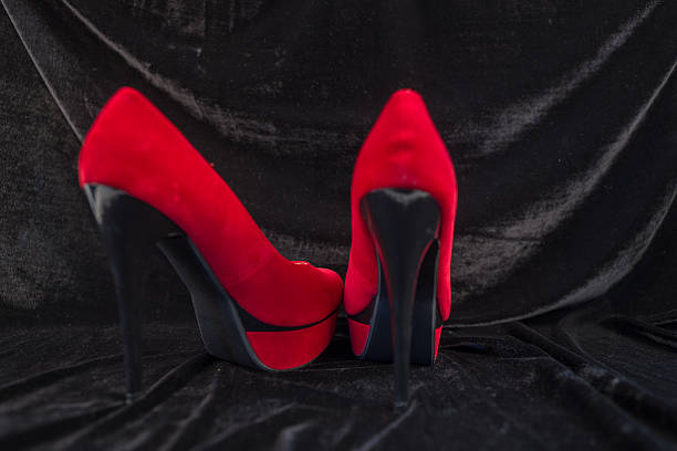 istock Women's red shoes isolated on black background 496124136