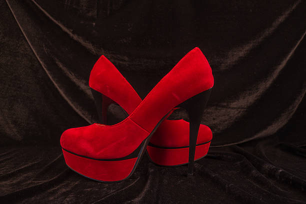 istock Women's red shoes isolated on black background 496124434