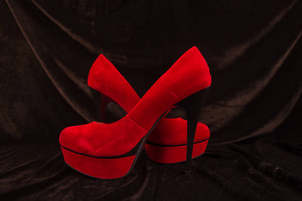 istock Women's red shoes isolated on black background 496124490