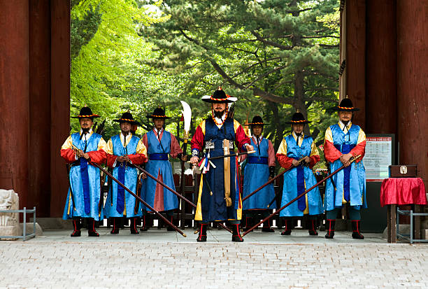 Seoul, South Korea - May 14, 2015:  Armed guards in traditional costume guard the entry gate at Deoksugung Palace, a tourist landmark, in Seoul, South Korea on May 14, 2015