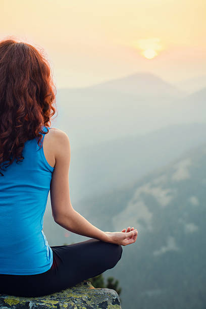 istock Woman meditating in the nature on sunset 496127346