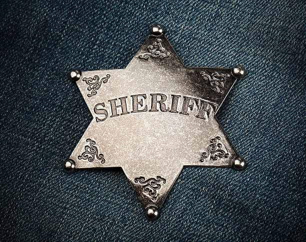 istock Sheriff star badge on blue denim background 496152976