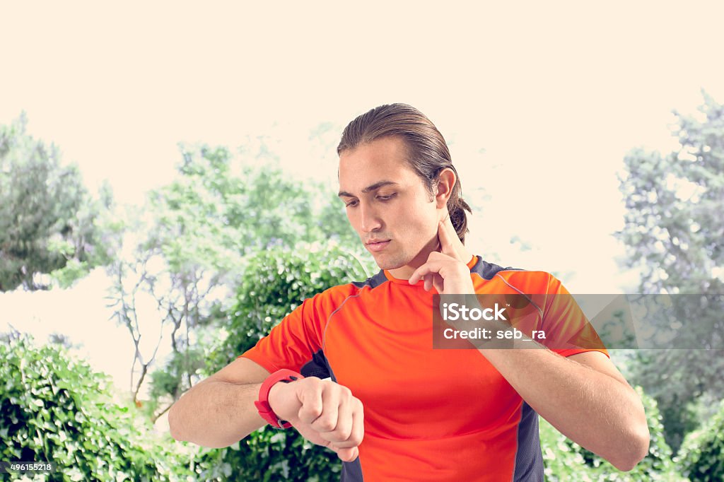 Sports man checking pulse 2015 Stock Photo