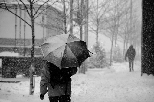 People walking on street in snowstorm in bw