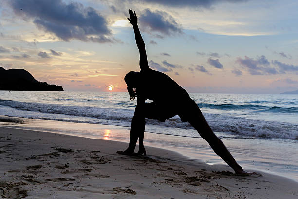 istock Woman meditating at the beach 496155907