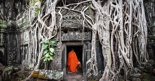 Angkor Wat monk. Ta Prom Khmer ancient Buddhist temple Angkor Wat monk. Ta Prom Khmer ancient Buddhist temple in jungle forest. Famous landmark, place of worship and popular tourist travel destination in Asia buddhist house of worship stock pictures, royalty-free photos & images