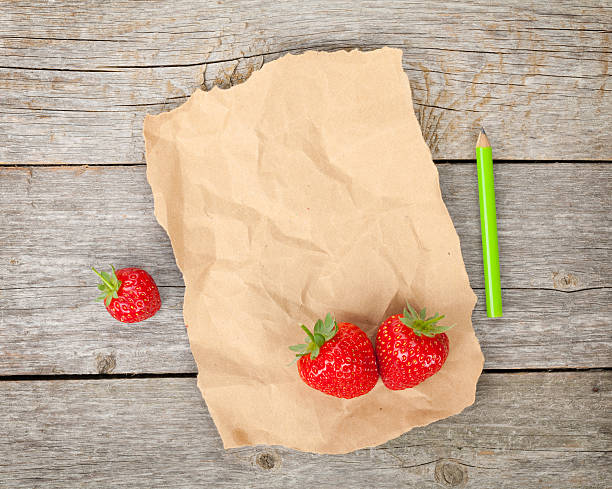 istock Blank paper and ripe strawberries over wooden table background 496156511
