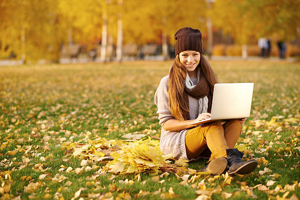 istock Using her laptop in the park on an autumn's day 496157208