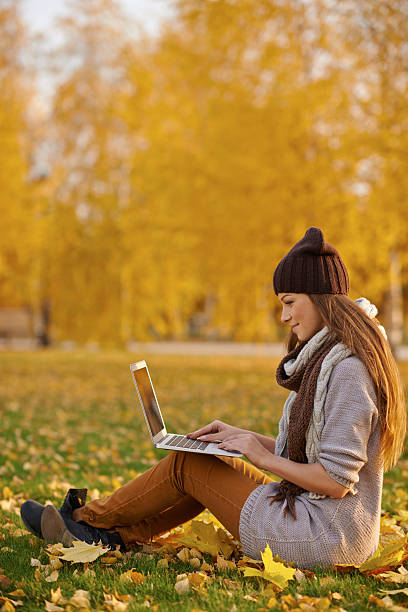 istock Using her laptop in the park on an autumn's day 496157422