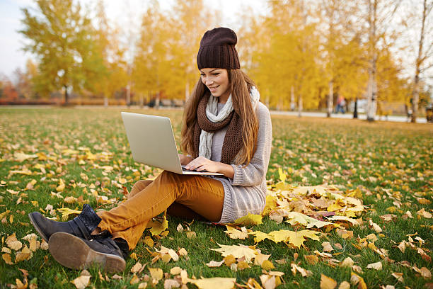 istock Using her laptop in the park on an autumn's day 496157570