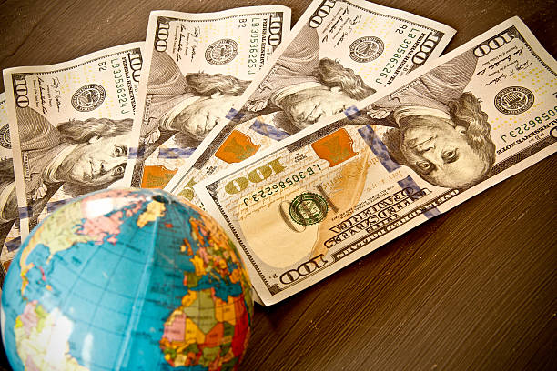 istock US Dollar currency and world globe 496160543