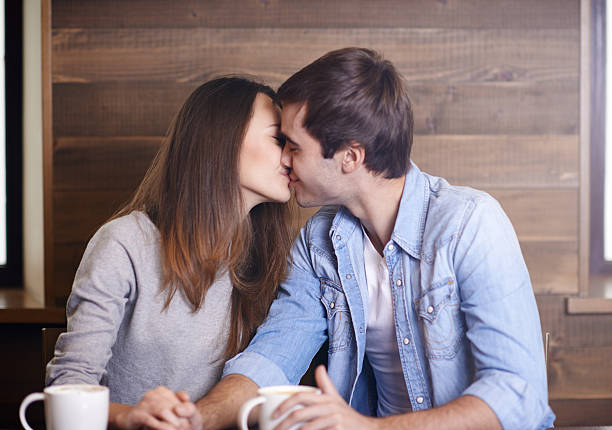 istock Affectionate young couple kissing in coffee shop 496161854