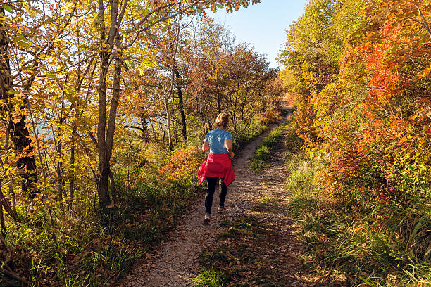 Caucasian mature woman running at sunset in autumn, Slovenia, Europe Mature  woman running on the stony path at sunset, smoke bush, Sabotin, Nova Gorica,Primorska, Slovenia, Europe.  Autumnal coloures.Nikon D3x primorska white sport nature stock pictures, royalty-free photos & images